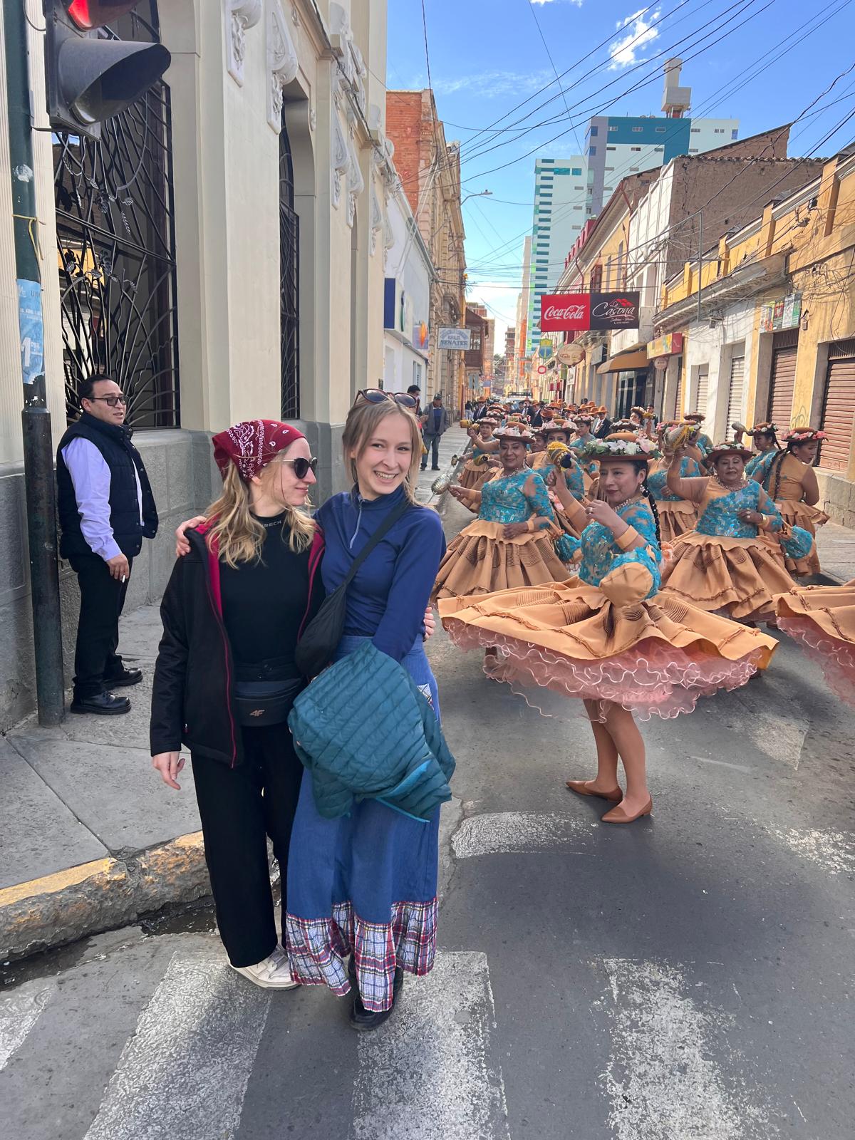 Na pierwszym planie Od lewej Weronika Tietz obok Zuzanna Krzywda w tle uczestnicy parady na ulicy.