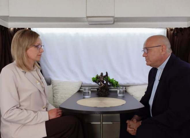 przy stole siedzą od lewej strony Agnieszka Janczura oraz ks. prof. UAM dr hab. Dariusz Kwiatkowski