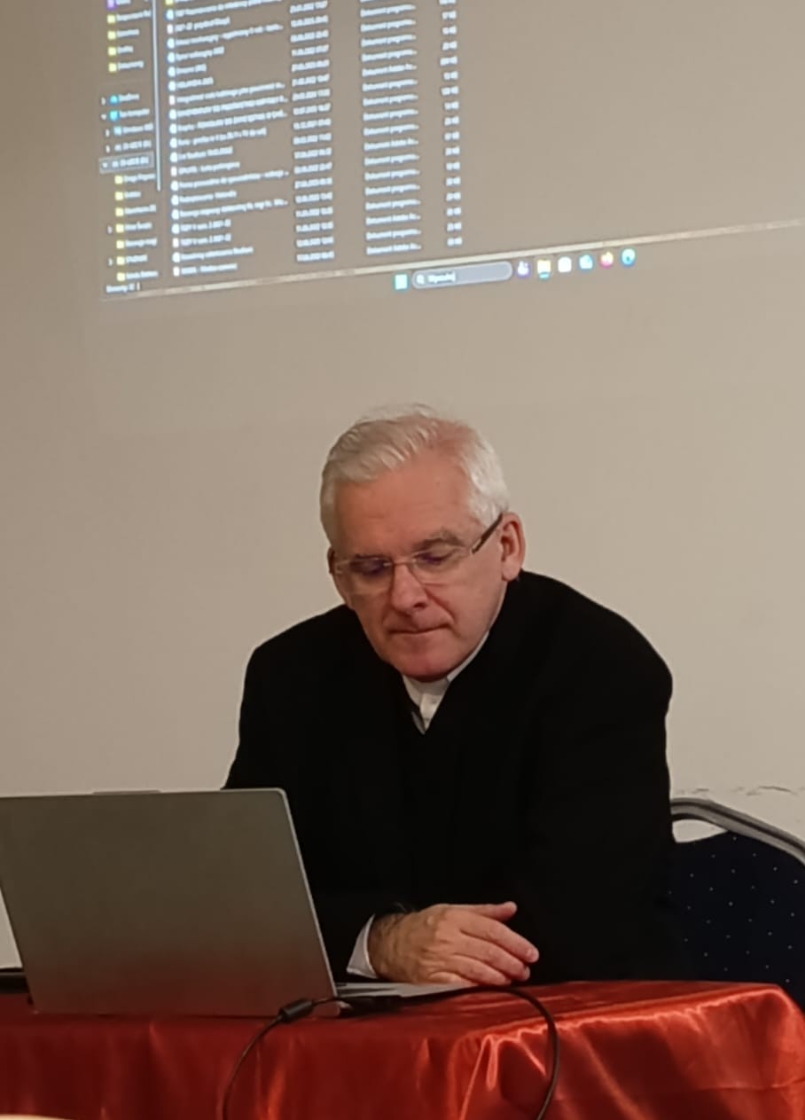 ks. prof. UAM dr hab. Maciej Olczyk siedzi przy stole