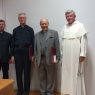 od lewej strony stojące postacie: ks. prof. UAM dr hab. Tomasz Nawracała, o. prof. UAM dr hab. Adam Wojtczak OMI, ks. prof. dr hab. Jan Daniel Szczurek, o. prof. Andrzej Napiórkowski